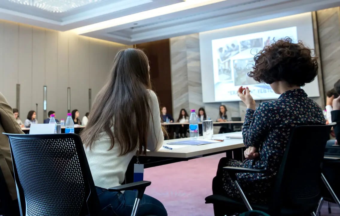 A group of women at business conference, exchanging insights to optimize trade spending in real-time