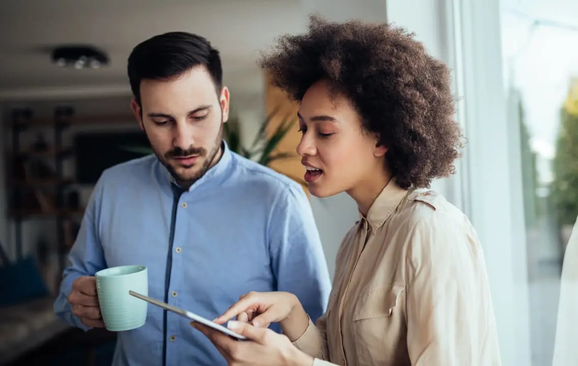 A man and woman collaborate on a tablet, working together to optimize and streamline their business processes